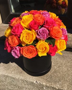 Dažādu krāsu rozes cilindriskā kastē