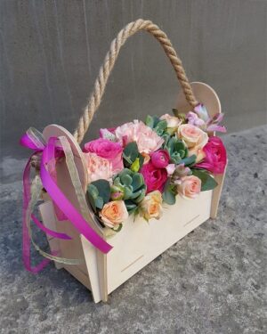 Rozā ziedu kompozīcija koka kastē